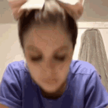 a woman in a blue shirt is washing her hair