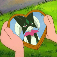 a person holding a heart shaped picture of a cat