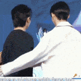 two men are hugging each other in front of a microphone with the words take a picture with fans too .