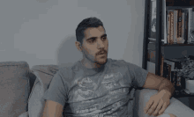 a man is sitting on a couch wearing a t-shirt that says ' paladinuk ' on the front