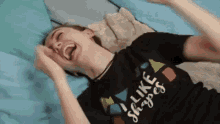 a woman is laying on her stomach on a bed and laughing .