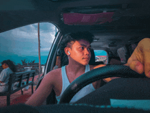 a man wearing ear buds sits in a car