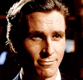 a close up of a man 's face in a suit and white shirt