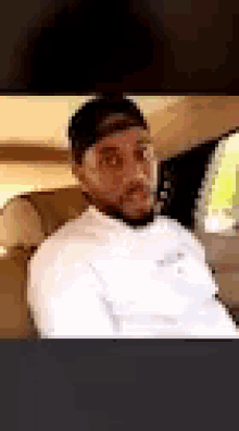 a man is sitting in the back seat of a car .