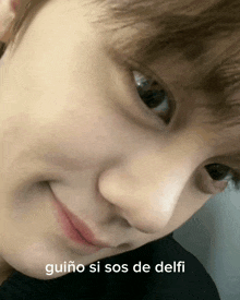 a close up of a person 's face with the words guiño si sos de delfi written below it