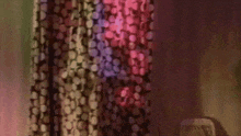 a blurred image of a curtain with a polka dot pattern and a purple light behind it .