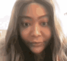 a woman with long hair is making a funny face .