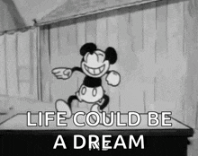 a black and white cartoon of mickey mouse dancing on a stage .