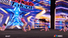 a group of young girls are performing on a stage in front of a screen that says america 's got talent