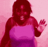 a woman in a pink tank top is waving her hand in a pink background .