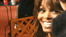 a close up of a woman 's face with a lattice in the background