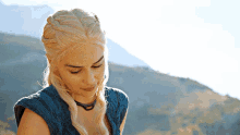 a woman with blonde hair is wearing a blue shirt