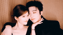 a man and a woman are posing for a picture and the man has a bracelet on his wrist that says cartier
