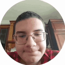 a young man wearing glasses and a red plaid shirt is making a funny face .