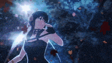 a girl in a black dress is standing in front of a tree with leaves flying around her .