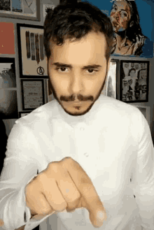 a man with a beard and mustache is pointing his finger at the camera