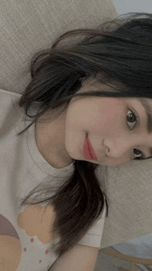 a girl with long hair is laying on a couch