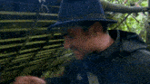 a man wearing a hat and a black jacket says that 's how you do it my son