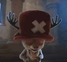 a teddy bear wearing a red hat with antlers and an x on it .