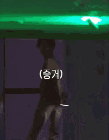 a person standing in front of a door with a green light behind them