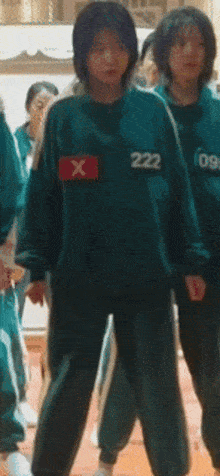a girl in a green uniform with the number 222 on her shirt