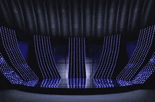 a group of skeletons are dancing on a stage in front of a wall of lights