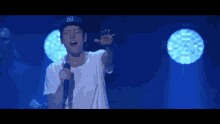 a man singing into a microphone while wearing a hat that says billabong