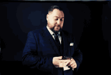 a man in a suit and tie is holding a glass