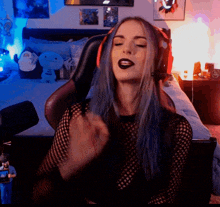 a woman with blue hair is wearing headphones