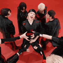 a group of people are standing around a person wearing a black shirt that says ete on it