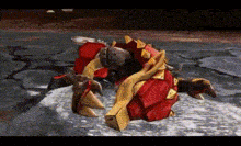 a red and yellow monster is laying on the ground in the snow .