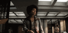 a woman in a plaid jacket is shaking hands with someone