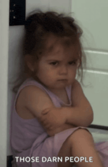 a little girl is sitting with her arms crossed and the words those darn people above her