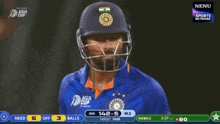a cricket player wearing a helmet and a blue shirt with the asian cup logo