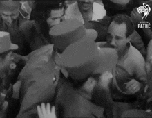 a man in a top hat is surrounded by other men in a black and white photo that says pathe on the bottom