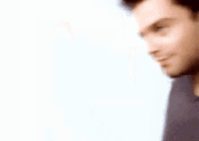 a blurry picture of a man 's face with a blue shirt on against a white background .