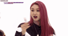 a woman with red hair is holding a piece of paper in her hand .