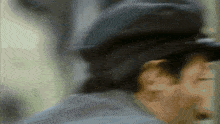 a blurry picture of a man wearing a hat and a jacket