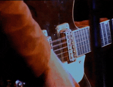 a close up of a person playing a guitar with a dark background