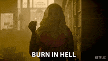 a woman holding a lit match with the words burn in hell written below her