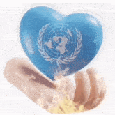 a person is holding a heart with the united nations flag on it