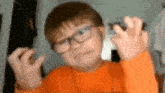 a young boy wearing glasses is making a funny face .