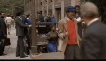 a man in a red sweater and a blue hat stands in front of a sign that says et station