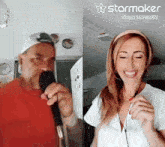 a man is singing into a microphone next to a woman who is smiling and wearing headphones