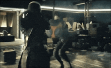 a group of people are standing in a dark room and one of them is wearing a mask