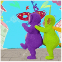 a purple and a green teddy bear from the teletubbies are dancing together .