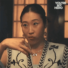 a woman is wearing a necklace and earrings with the words " you 're my hero " on the bottom right