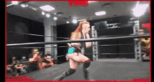 a woman is wrestling in a wrestling ring while a crowd watches .