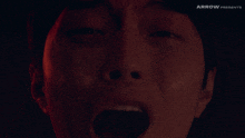 a close up of a person 's face with the words arrow presents above