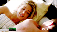a woman is laying in bed next to a man with a cw logo on the bottom right